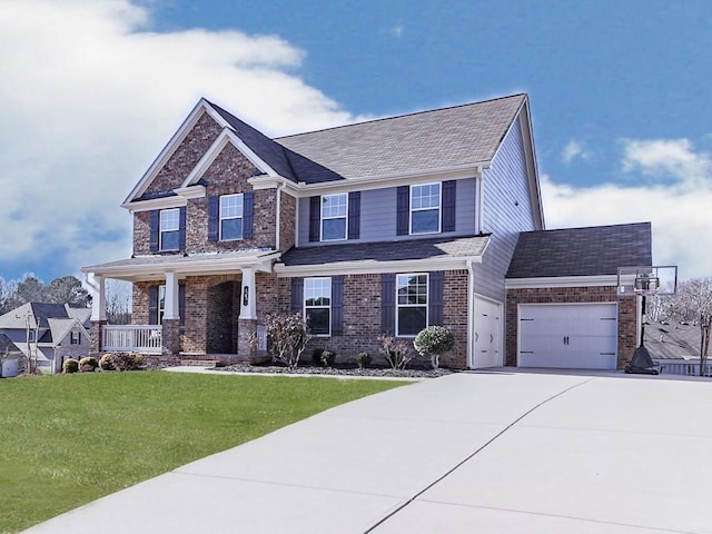 craftsman inspired home with brick siding, a front lawn, a porch, a garage, and driveway