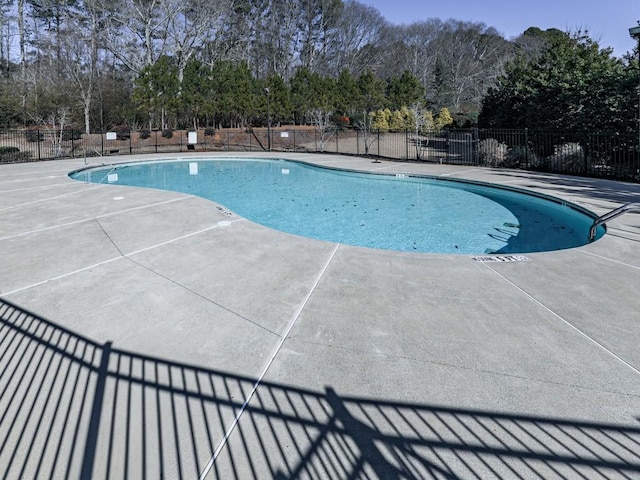 community pool featuring a patio area and fence