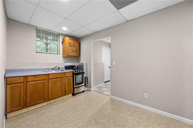 470 Piney Way SW, Atlanta, GA 30331 - kitchen with stainless steel gas stove, a sink, baseboards, light countertops, and brown cabinets