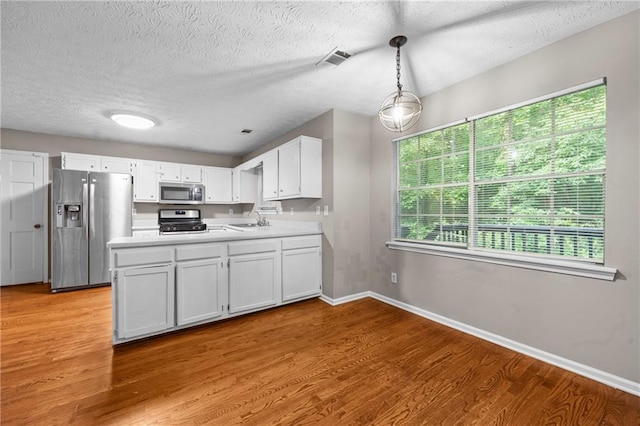 470 Piney Way SW, Atlanta, GA 30331 - kitchen featuring appliances with stainless steel finishes, a peninsula, light wood-style floors, a sink, and white cabinetry