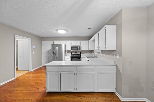 470 Piney Way SW, Atlanta, GA 30331 - kitchen with appliances with stainless steel finishes, a sink, light countertops, a peninsula, and baseboards