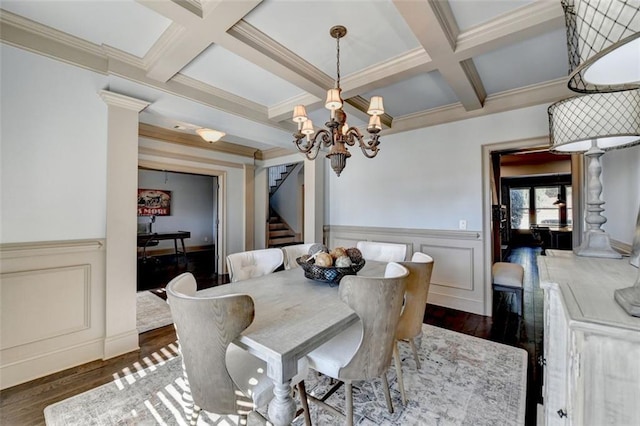 dining space featuring coffered ceiling, dark wood-type flooring, crown molding, and beam ceiling