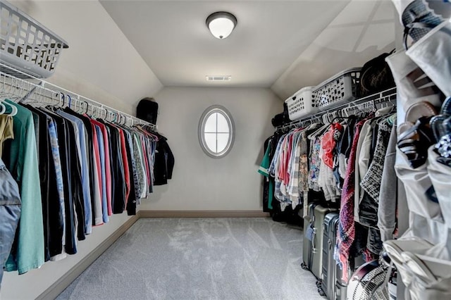 walk in closet featuring light carpet and lofted ceiling