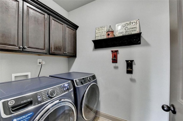 clothes washing area featuring separate washer and dryer and cabinets