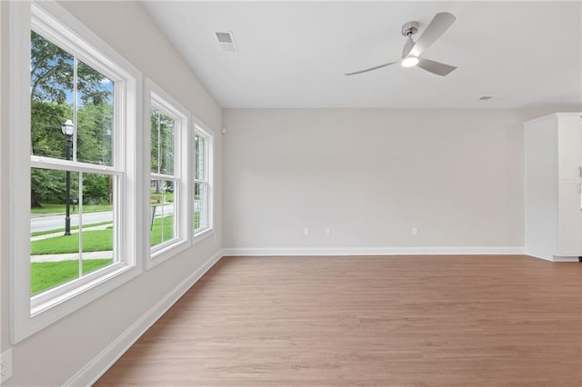 unfurnished room with light wood-style floors, baseboards, and a ceiling fan