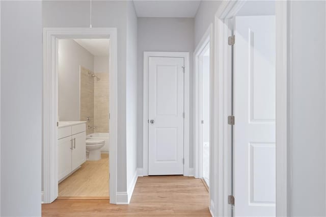 hall featuring light wood-type flooring and baseboards