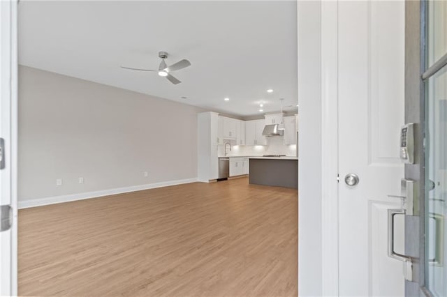 unfurnished living room featuring light wood finished floors, baseboards, a ceiling fan, and recessed lighting