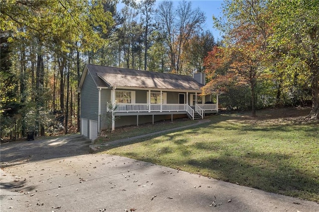 view of front of home with a garage, covered porch, and a front yard