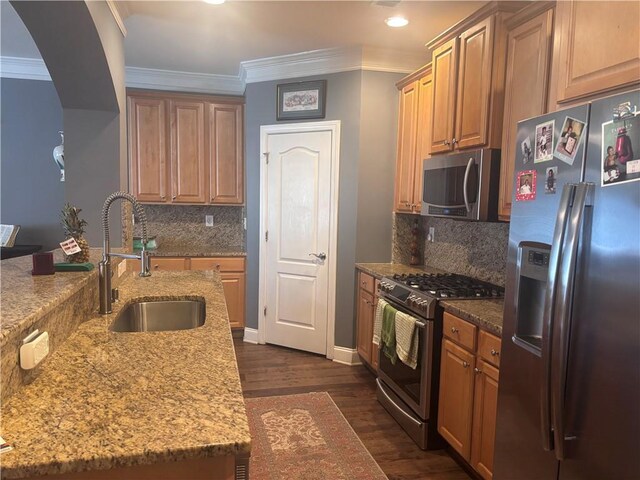 2610 Gadsen Walk, Duluth, GA 30097 - kitchen with light stone counters, a sink, ornamental molding, appliances with stainless steel finishes, and dark wood-style floors