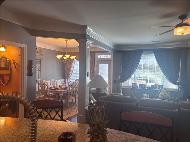 2610 Gadsen Walk, Duluth, GA 30097 - living area featuring crown molding, a wealth of natural light, decorative columns, and ceiling fan with notable chandelier