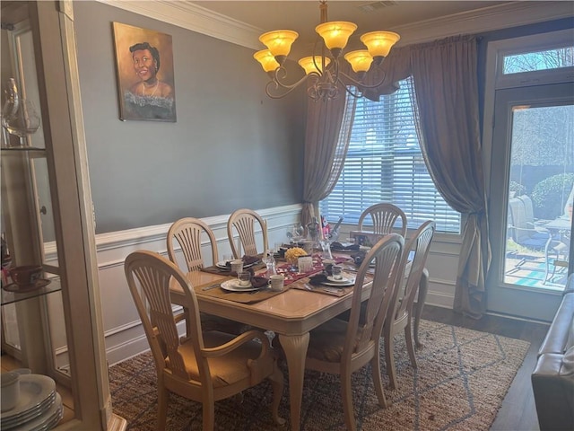 2610 Gadsen Walk, Duluth, GA 30097 - dining area featuring a chandelier, wainscoting, a decorative wall, and ornamental molding