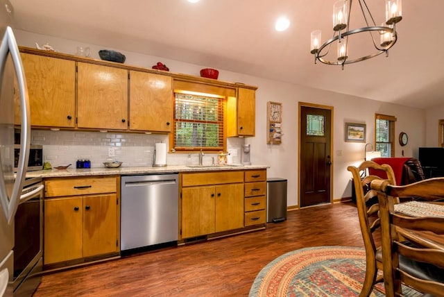 kitchen featuring pendant lighting, dark wood-type flooring, stainless steel appliances, tasteful backsplash, and a chandelier