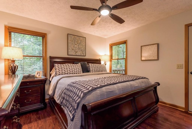 bedroom with ceiling fan, dark wood-type flooring, and a textured ceiling