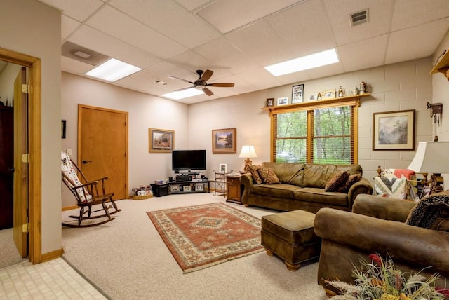 carpeted living room featuring ceiling fan and a drop ceiling