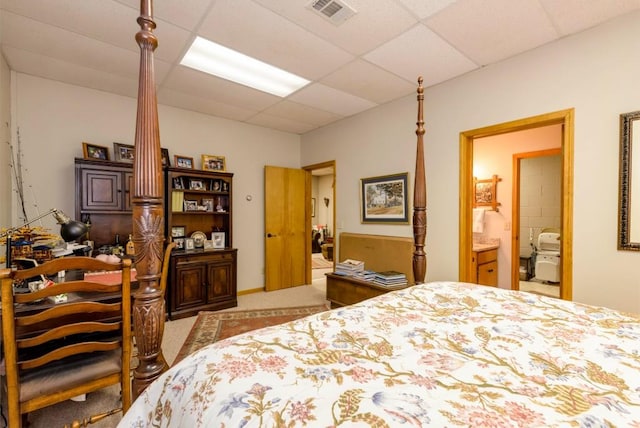 carpeted bedroom featuring connected bathroom and a paneled ceiling