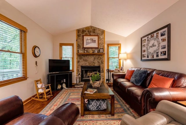 living room with wood-type flooring, a fireplace, vaulted ceiling, and a wealth of natural light