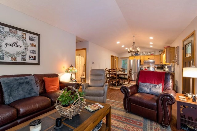 living room with an inviting chandelier, lofted ceiling, and hardwood / wood-style flooring