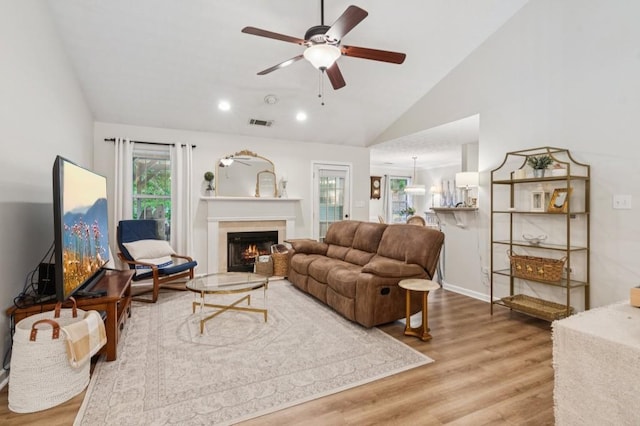 2277 Lazy Days Rd, Dacula, GA 30019 - living room featuring lofted ceiling, wood finished floors, a ceiling fan, a warm lit fireplace, and baseboards