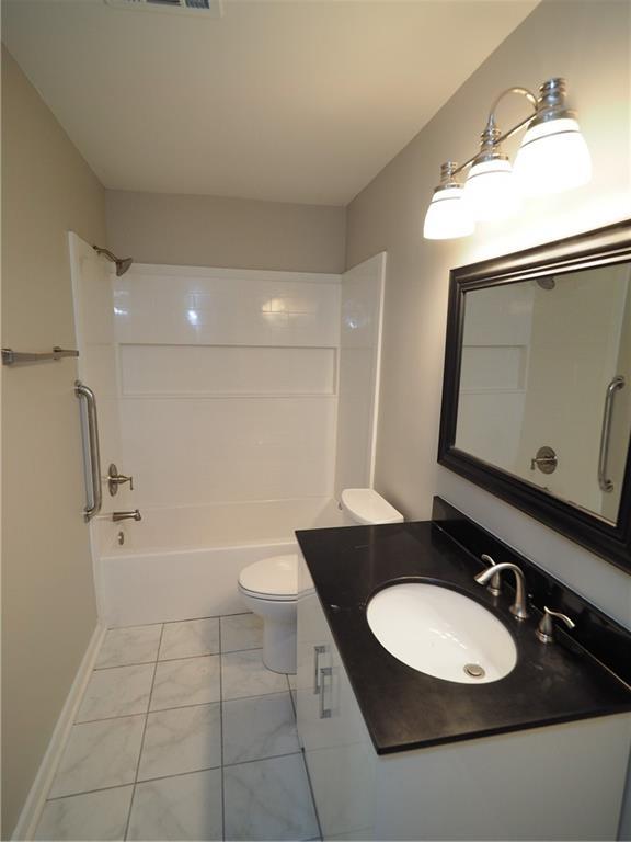 bathroom featuring toilet, visible vents, shower / bathtub combination, and vanity