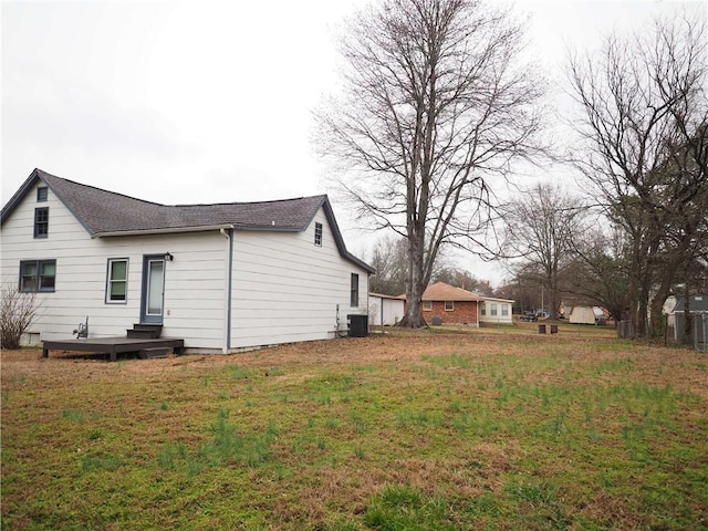 view of side of property with central AC unit and a lawn