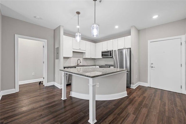 840 United Ave SE Unit 401, Atlanta, GA 30312 - kitchen featuring stainless steel appliances, light stone countertops, a kitchen island, dark wood-style flooring, and baseboards