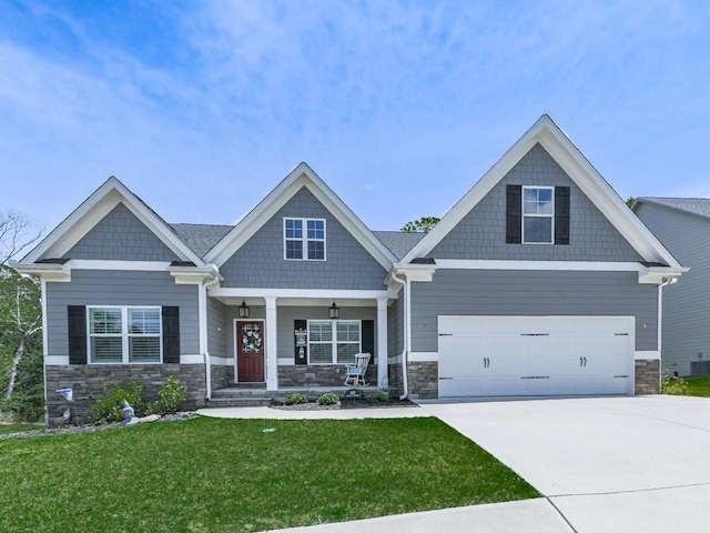 craftsman-style home featuring stone siding, a porch, concrete driveway, a front lawn, and central AC unit