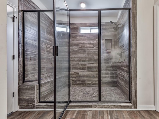 full bath with a shower stall and wood finished floors