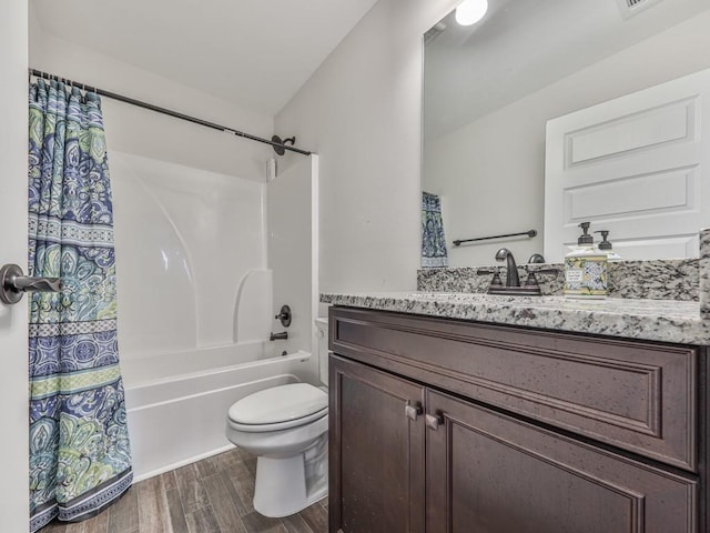 full bath featuring wood finished floors, toilet, vanity, and shower / bath combo with shower curtain