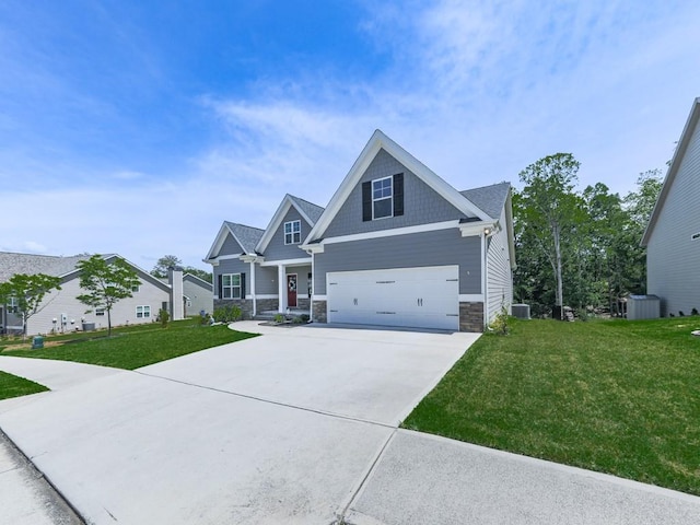 craftsman house featuring stone siding, driveway, a front lawn, and a garage