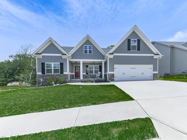 craftsman-style home featuring stone siding, covered porch, driveway, and a front yard