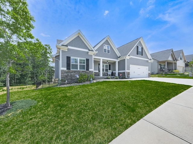 craftsman-style home featuring a porch, stone siding, driveway, and a front lawn
