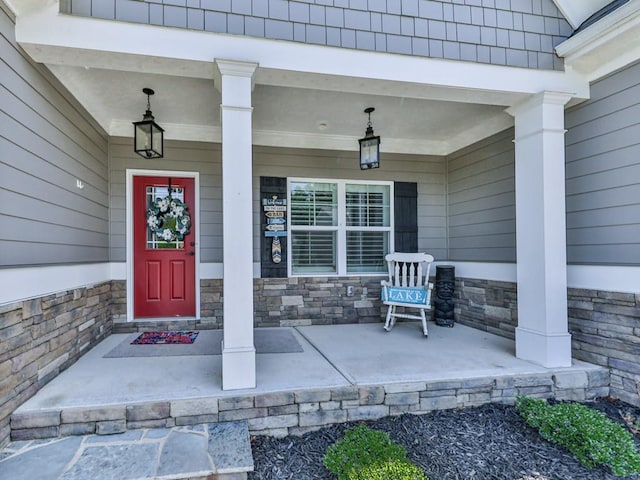 property entrance featuring a porch and stone siding