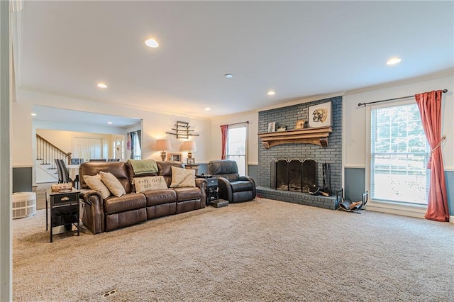 carpeted living room with a brick fireplace, crown molding, and a healthy amount of sunlight