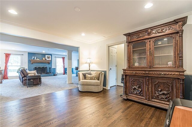 living room with crown molding, dark hardwood / wood-style flooring, and a fireplace