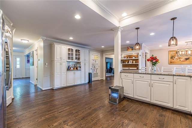 kitchen featuring pendant lighting, white cabinets, light stone counters, and dark hardwood / wood-style floors