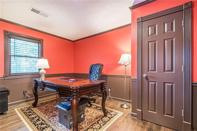 office featuring a textured ceiling, ornamental molding, and light hardwood / wood-style floors