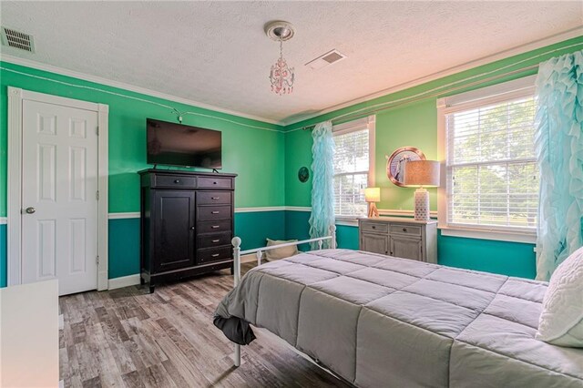 bedroom featuring a textured ceiling and light wood-type flooring