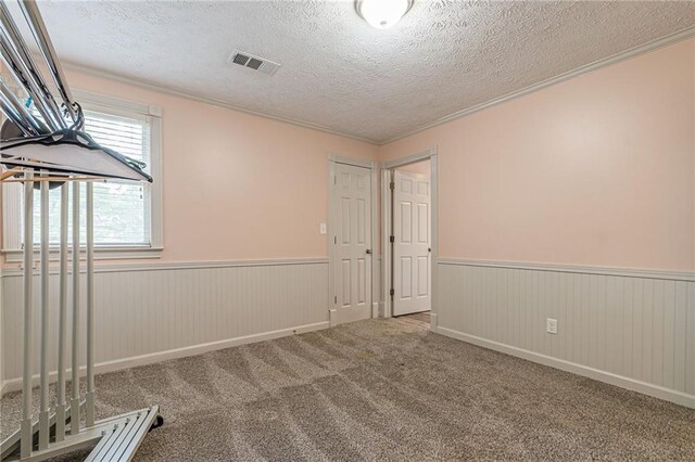 exercise room featuring wood walls, a textured ceiling, and carpet flooring