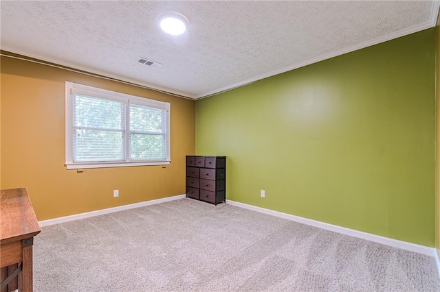 empty room featuring crown molding, carpet floors, and a textured ceiling