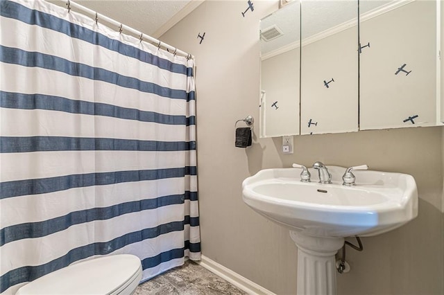 bathroom featuring sink, toilet, walk in shower, and a textured ceiling