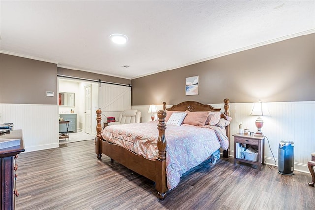 bedroom with a barn door, dark wood-type flooring, and crown molding