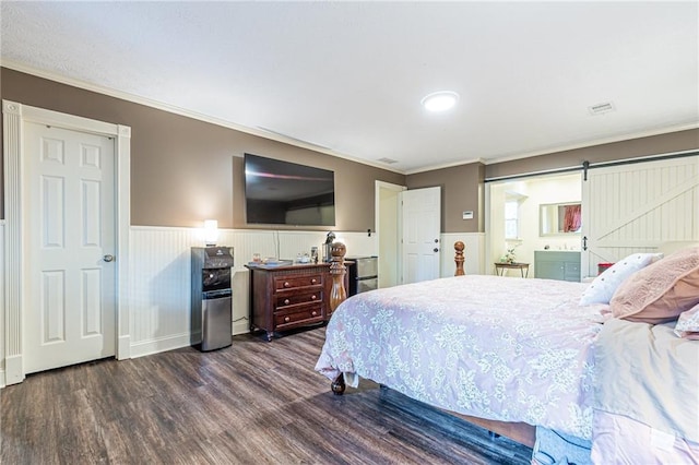 bedroom featuring crown molding, dark wood-type flooring, and a barn door