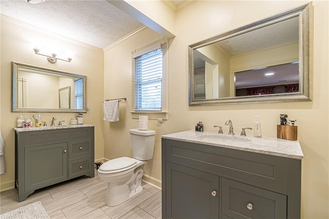 bathroom featuring toilet, ornamental molding, vanity, and a textured ceiling