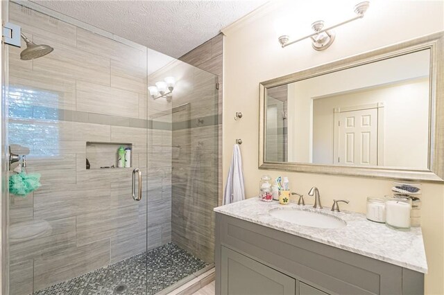 bathroom with vanity, toilet, a textured ceiling, and ornamental molding