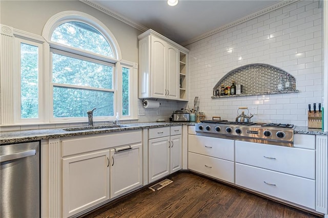 kitchen with tasteful backsplash, dark hardwood / wood-style flooring, appliances with stainless steel finishes, white cabinetry, and sink