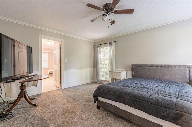 carpeted bedroom featuring ceiling fan, crown molding, a textured ceiling, and ensuite bathroom