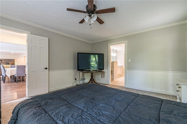 carpeted bedroom with crown molding, connected bathroom, and ceiling fan