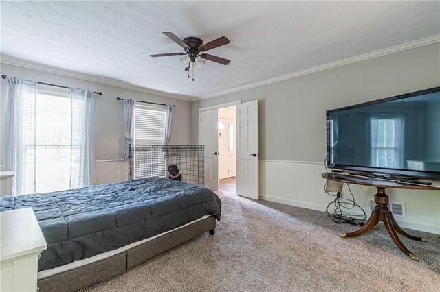 carpeted bedroom with ceiling fan, a textured ceiling, ornamental molding, and ensuite bathroom