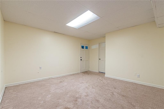 carpeted empty room featuring a drop ceiling