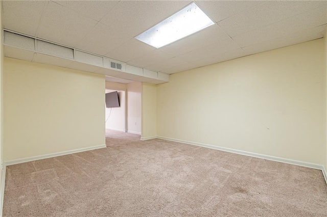 carpeted spare room with a drop ceiling